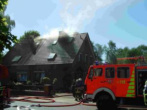 Während ein Trupp unter PA im Gebäudeinneren gegen die Flammen vorgeht, wird von außen über die Drehleiter ein Löschangriff vorbereitet.
