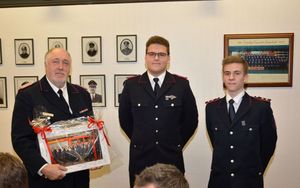 Die alte und neue Jugendleitung (Hendrik Köncke, Rasmus Feindt) dankt Wolfgang Schramm mit einem aktuellem Bild der Jugendfeuerwehr