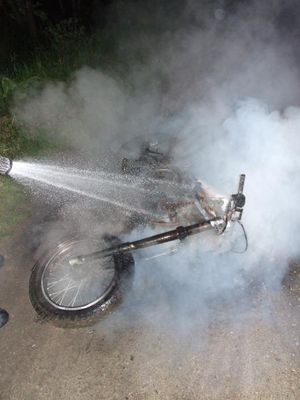 Das brennende Motorrad wird abgelöscht.