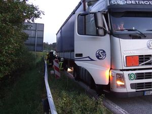 Der LKW auf dem Standstreifen, am Trailer die Kameraden beim Kühlen der defekten Bremse