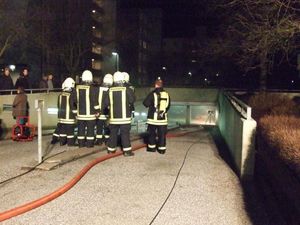Die Einsatzleitung im Gespräch mit den Gruppenführern, im Hintergrund das Tor der Garage.